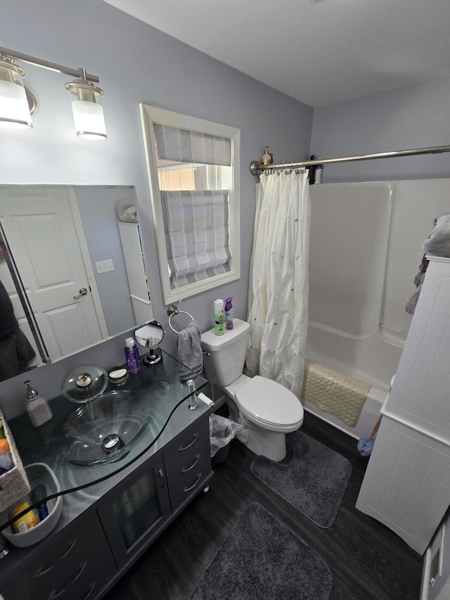 bathroom with toilet, vanity, a shower with curtain, and wood finished floors