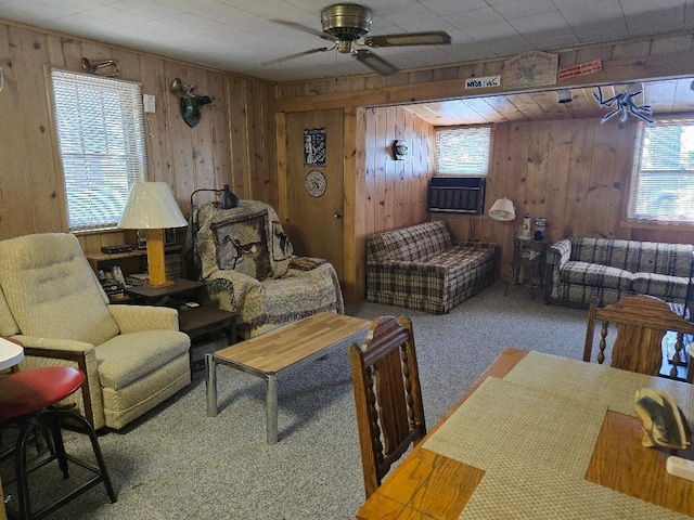 carpeted living room with wooden walls and ceiling fan