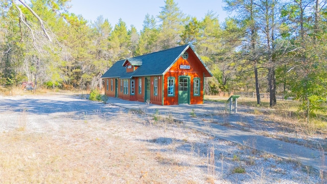 view of front of home with a wooded view