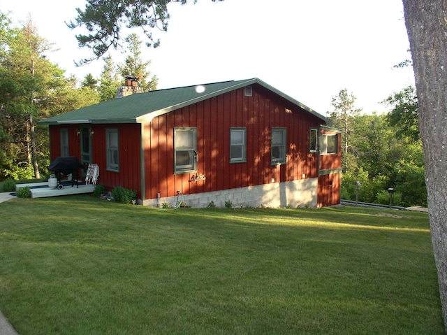 view of side of property featuring a yard and a chimney