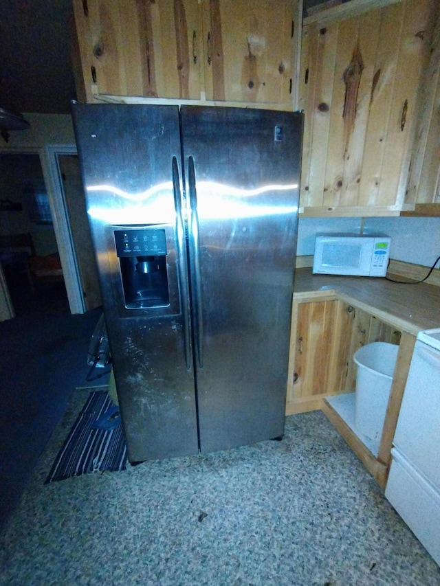 kitchen featuring stainless steel fridge with ice dispenser and white microwave