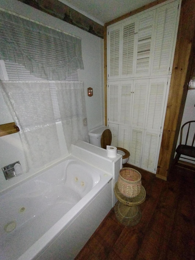 bathroom with wood finished floors and a tub