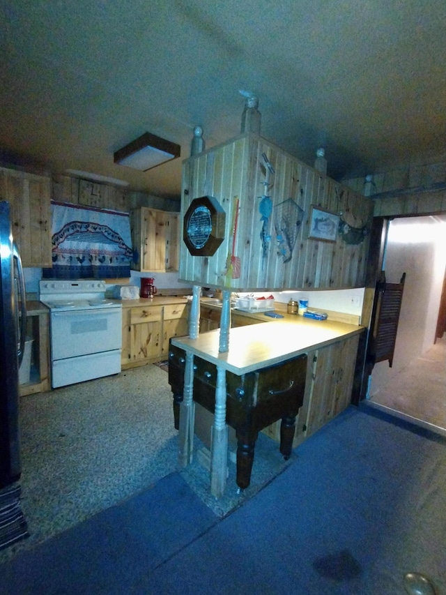 kitchen with white electric stove, freestanding refrigerator, and carpet floors