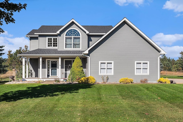 view of front of house featuring a front lawn, covered porch, and a shingled roof