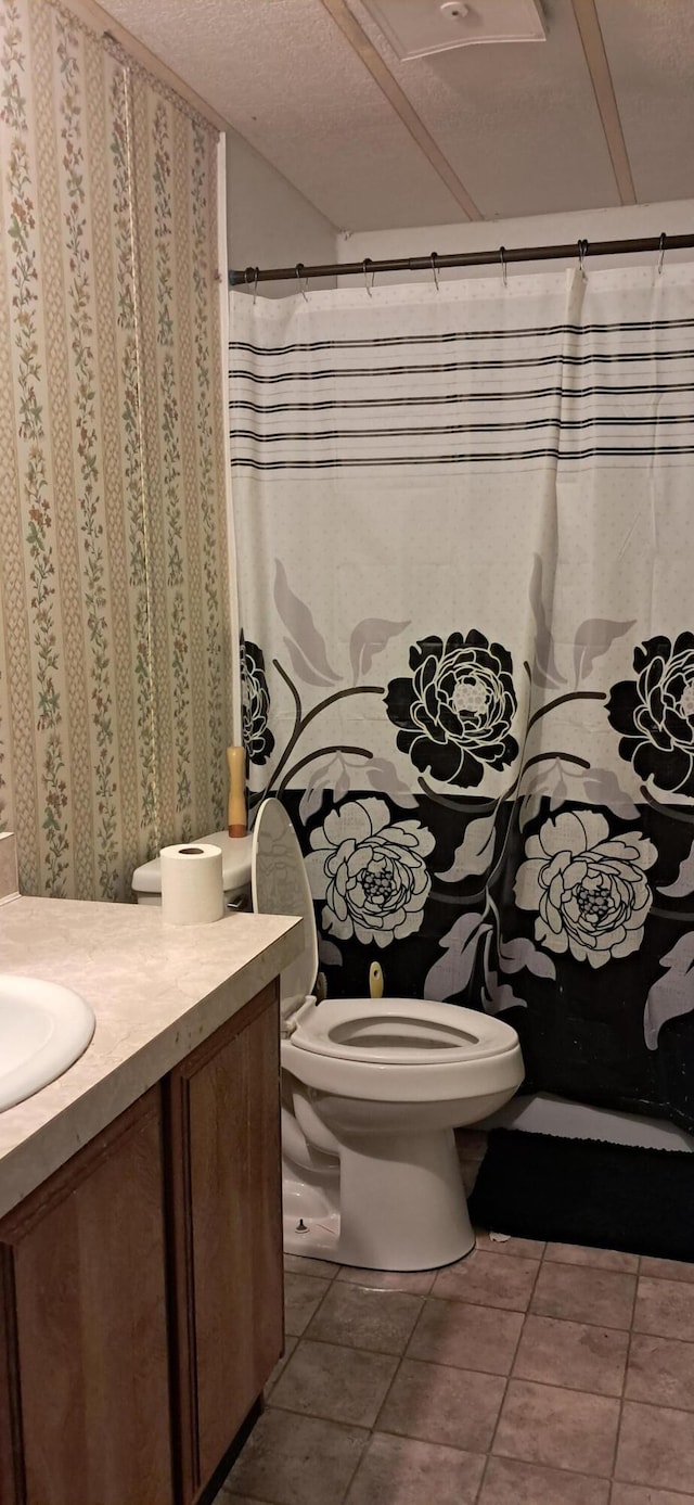 full bathroom featuring a shower with curtain, toilet, a textured ceiling, tile patterned flooring, and vanity