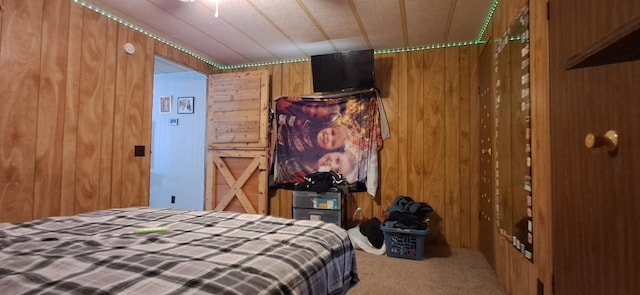 bedroom featuring wood walls and carpet