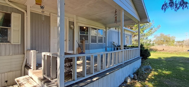 wooden terrace featuring a yard and covered porch