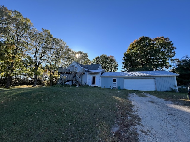 view of front of property with stairway, a front yard, a garage, a deck, and driveway