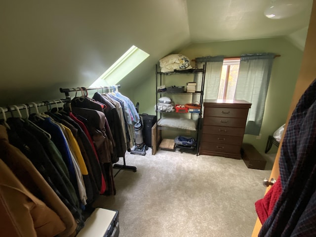 walk in closet featuring lofted ceiling with skylight and carpet floors