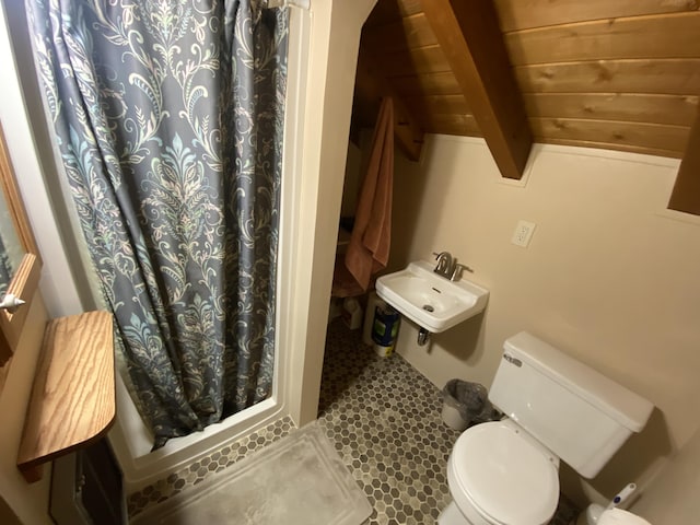 bathroom featuring a sink, beam ceiling, toilet, and a shower with shower curtain