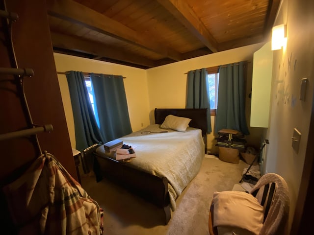 carpeted bedroom featuring beamed ceiling and wooden ceiling