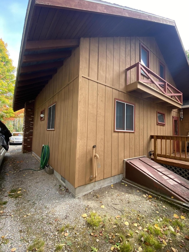 view of side of home featuring a balcony and board and batten siding