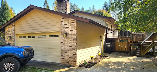 view of property exterior with stairs, a garage, brick siding, and a chimney