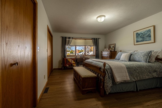 bedroom featuring wood finished floors, visible vents, and baseboards