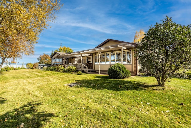 rear view of property featuring a wooden deck, a yard, and a pergola