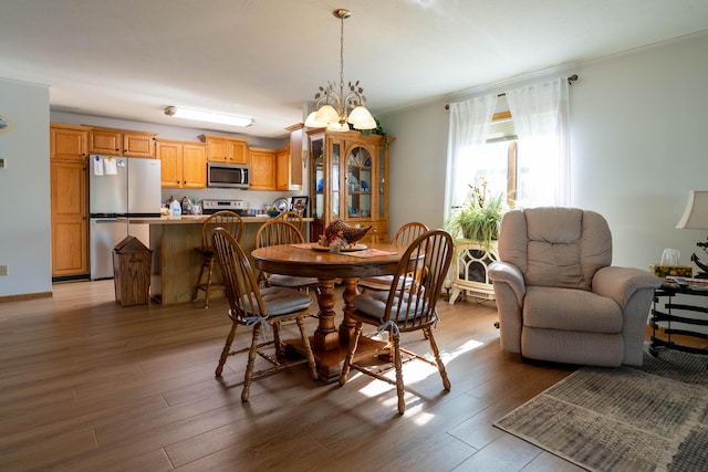 dining room featuring an inviting chandelier, wood finished floors, and ornamental molding