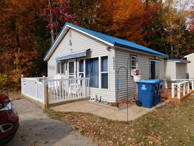 bungalow-style house with metal roof and a deck