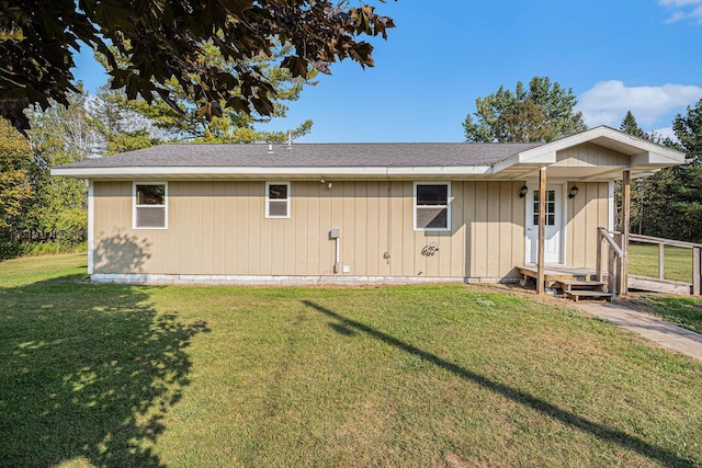 view of front of property featuring a shingled roof and a front lawn