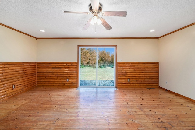 unfurnished room with rustic walls, a textured ceiling, crown molding, and hardwood / wood-style floors