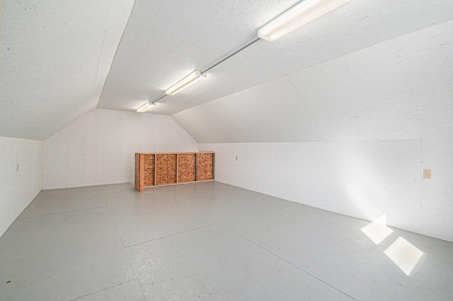 bonus room featuring a textured ceiling and vaulted ceiling