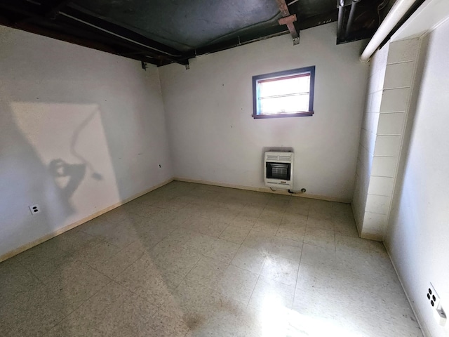 below grade area featuring heating unit and tile patterned floors