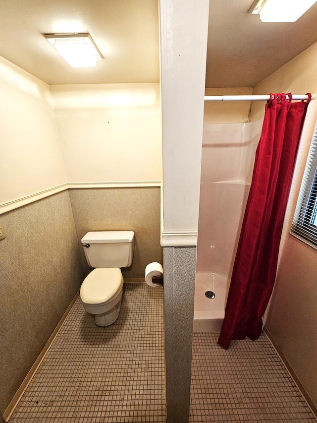 full bathroom featuring tile patterned flooring, toilet, and a stall shower