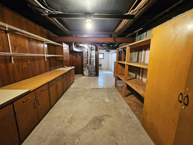 unfinished basement featuring heating unit and wood walls