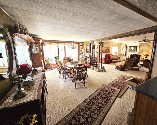 carpeted dining room featuring a textured ceiling