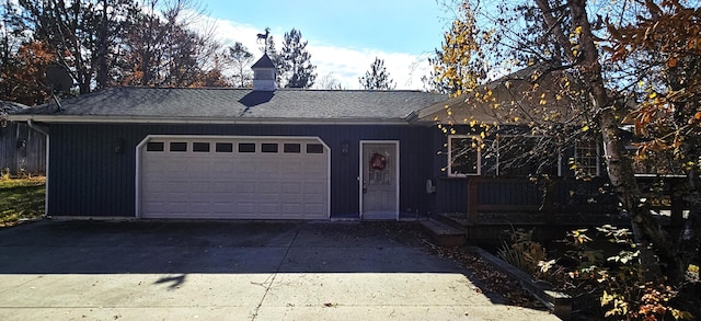 ranch-style house with driveway, a chimney, a garage, and roof with shingles