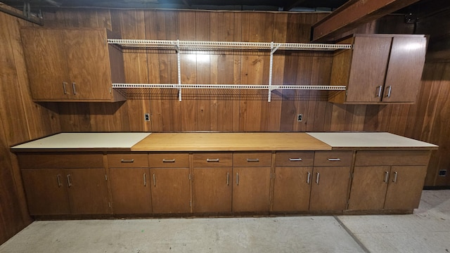 kitchen with light countertops, open shelves, and wooden walls