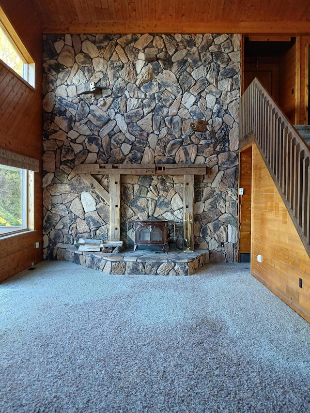 unfurnished living room featuring wood ceiling and wood walls