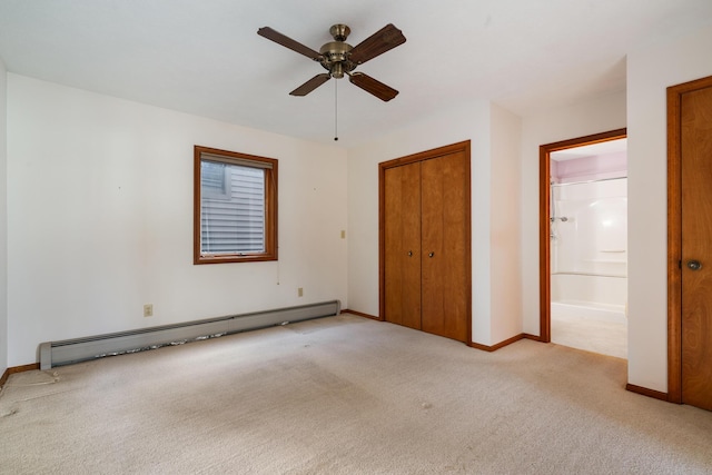 unfurnished bedroom featuring baseboards, a closet, ensuite bathroom, a baseboard heating unit, and light colored carpet