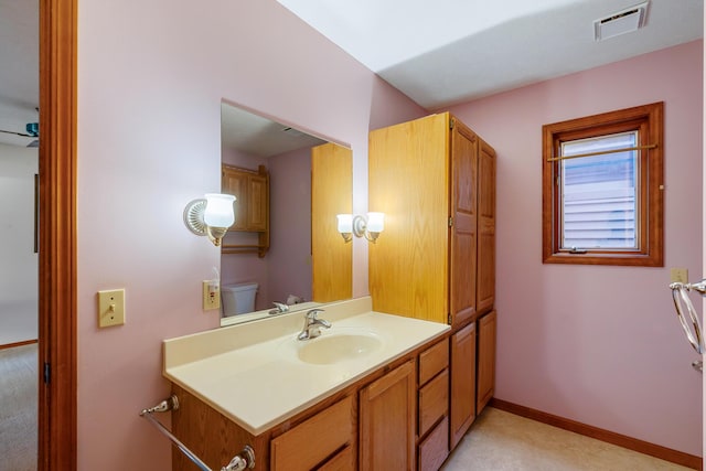bathroom with vanity, toilet, baseboards, and visible vents