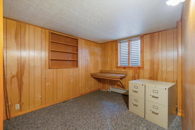 misc room featuring a baseboard radiator, carpet floors, visible vents, and wood walls