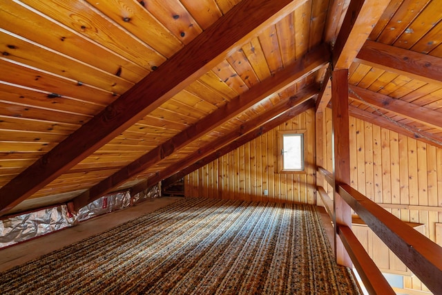 additional living space with carpet flooring, wooden walls, wooden ceiling, and vaulted ceiling with beams