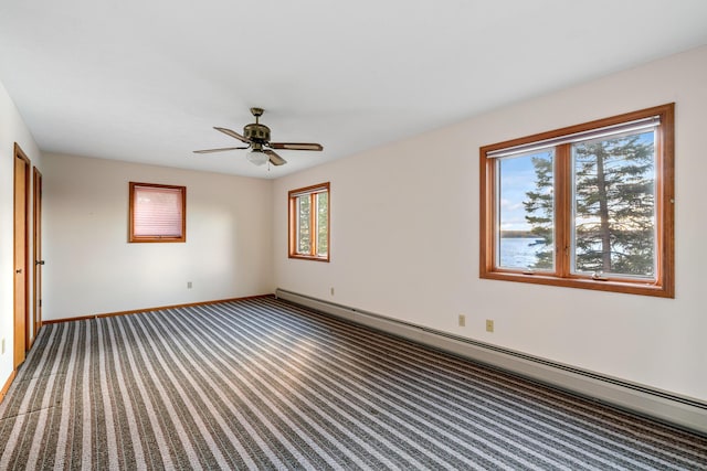 carpeted spare room featuring baseboard heating, ceiling fan, and baseboards