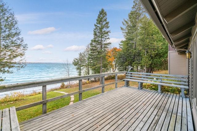 wooden deck featuring a beach view and a water view