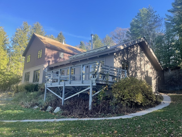 back of property featuring a deck and a yard