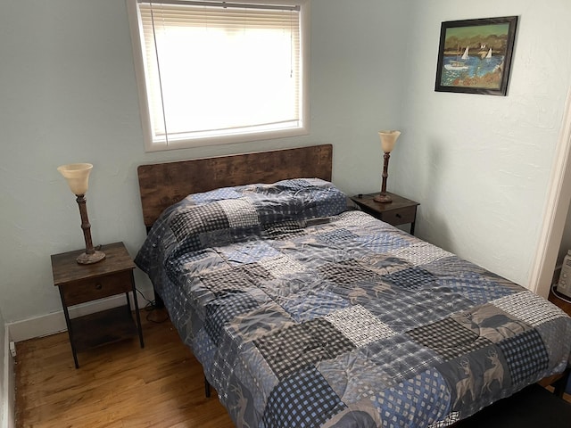 bedroom featuring wood finished floors and baseboards