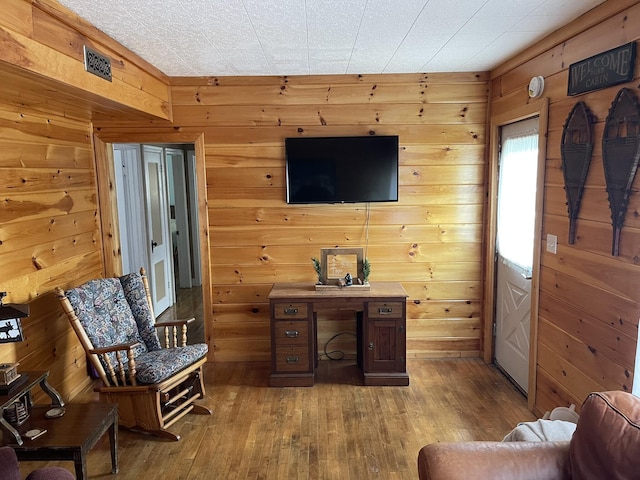 living room with wooden walls and hardwood / wood-style flooring