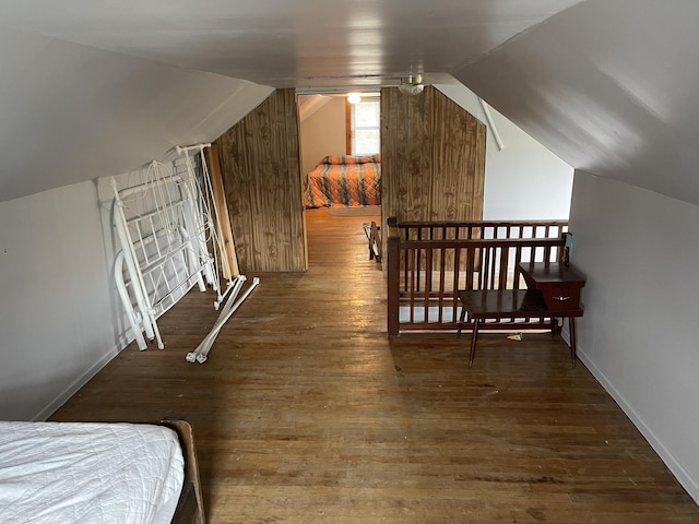 bedroom featuring vaulted ceiling, baseboards, and hardwood / wood-style flooring