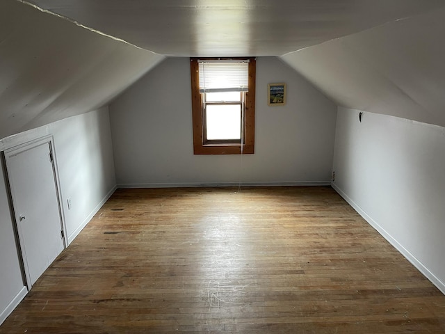 bonus room featuring wood finished floors and vaulted ceiling