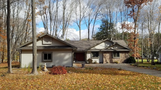 view of front of property with aphalt driveway and stone siding