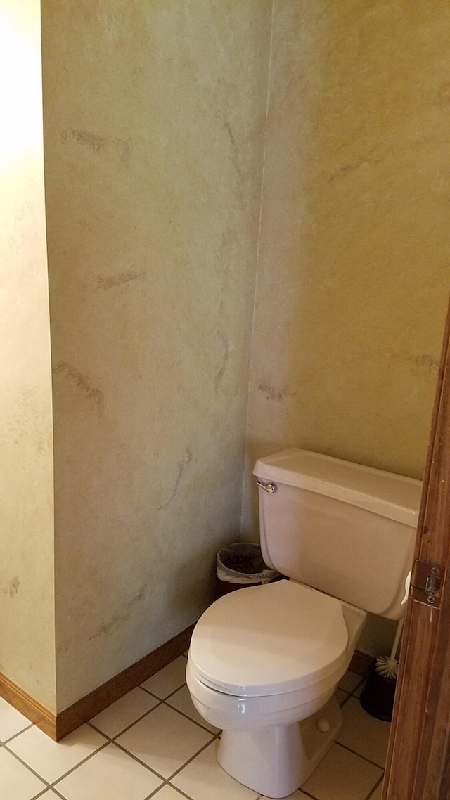 bathroom featuring tile patterned floors, toilet, and baseboards