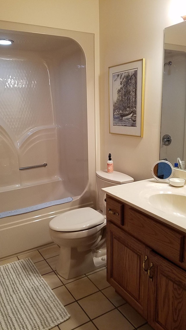 bathroom featuring tile patterned floors, toilet, shower / washtub combination, and vanity