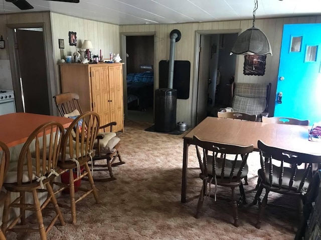 carpeted dining space featuring a wood stove