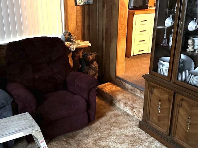 sitting room featuring wood walls and carpet floors