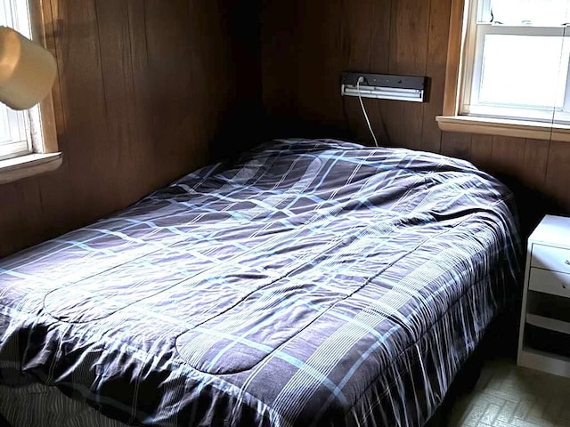 bedroom featuring wood walls