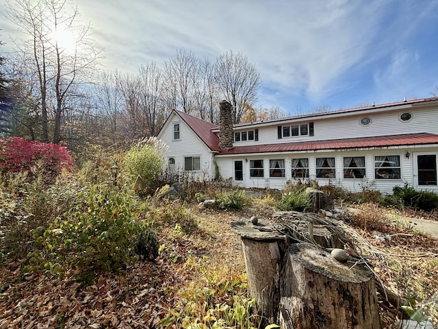 rear view of property featuring a chimney