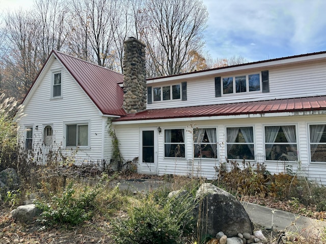 view of front of house with a chimney and metal roof